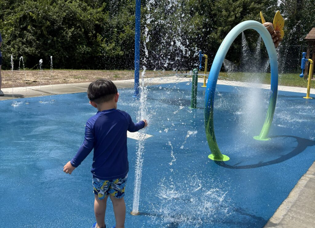 Toddler playing at Palisades Park Swim Club splash pad