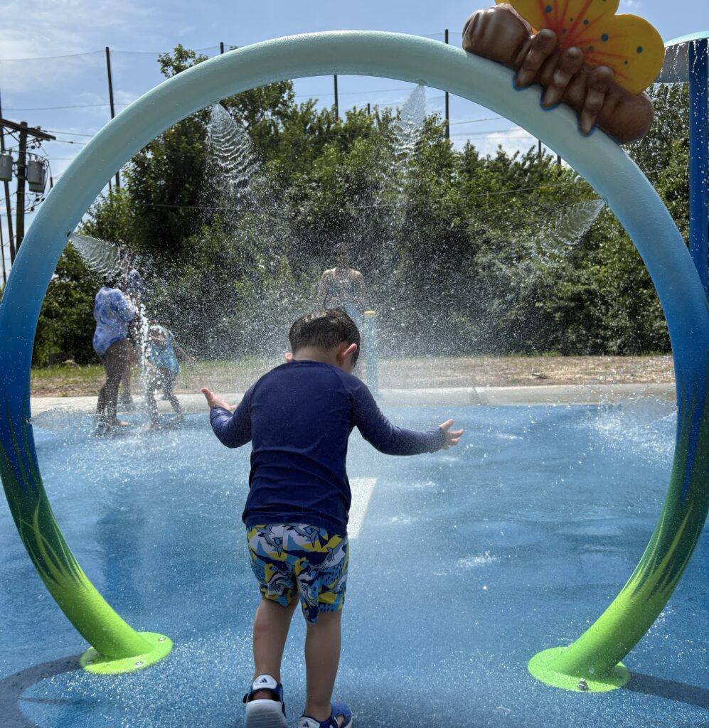 Toddler playing at Palisades Park Swim Club splash pad